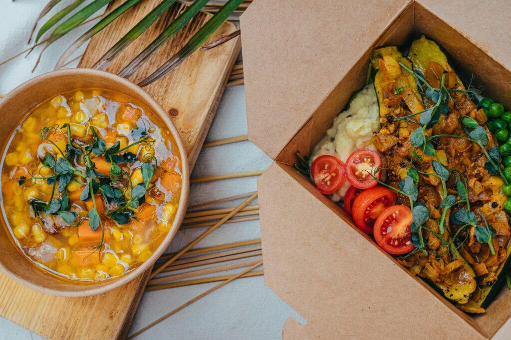 在桌上擺著2個裝著食物的環保外帶餐盒，看起來非常美味